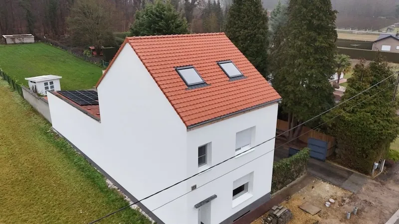 Nieuw hellend dak in rode pannen met twee dakramen